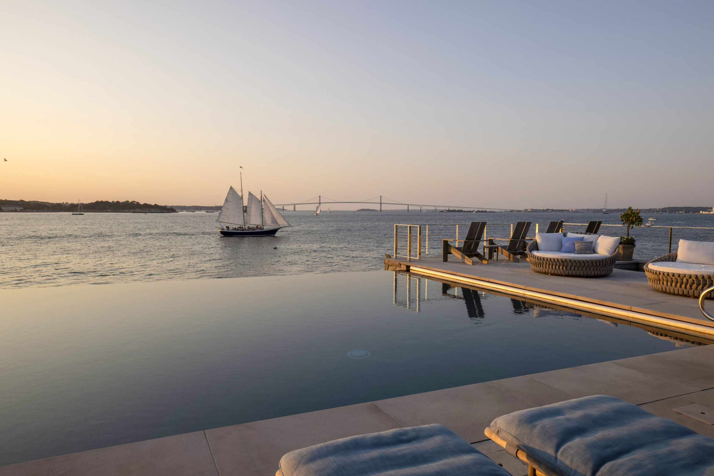 An infinity pool appears to merge with Narragansett Bay at sunset