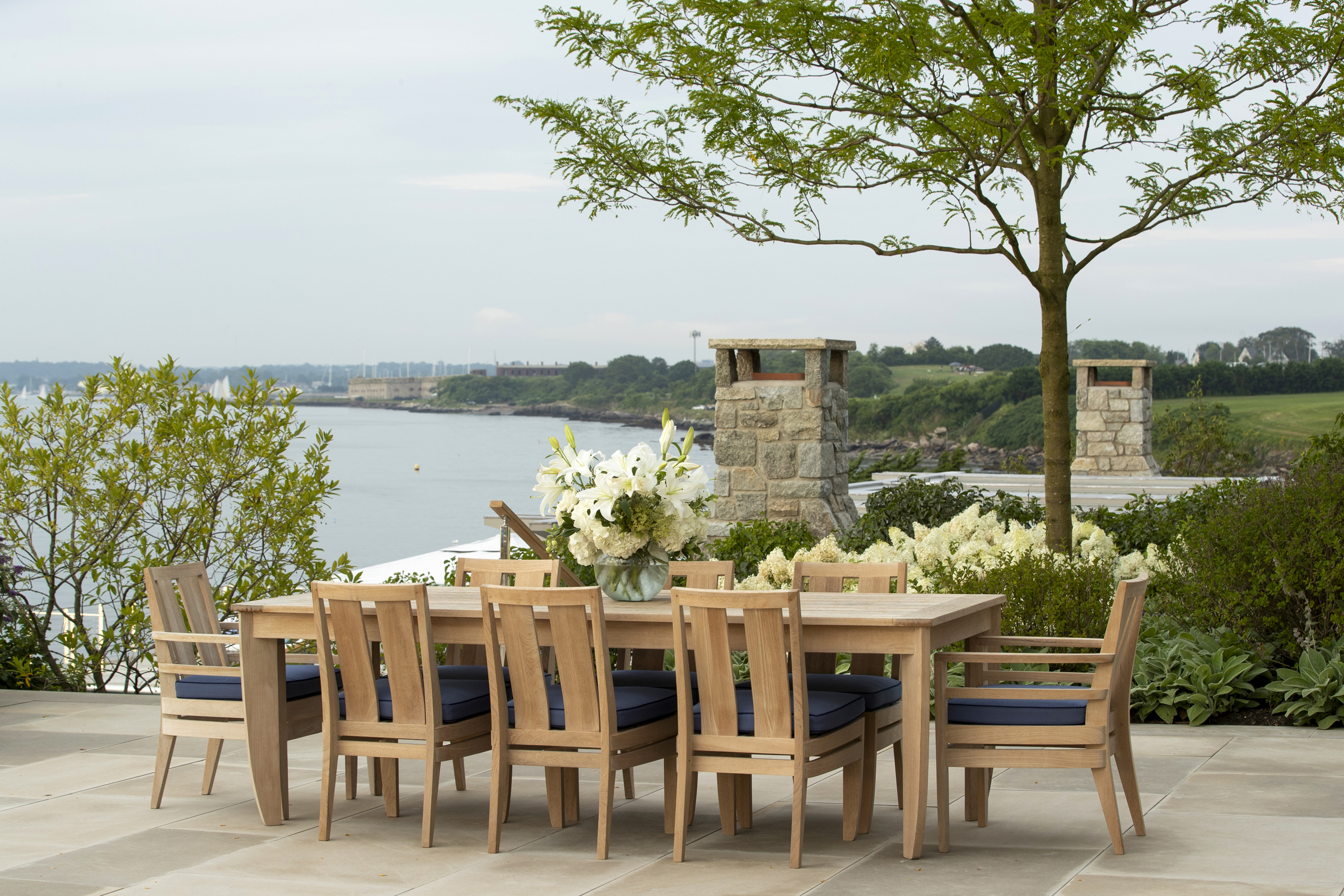 A teak dining table for ten overlooks Newport Harbor