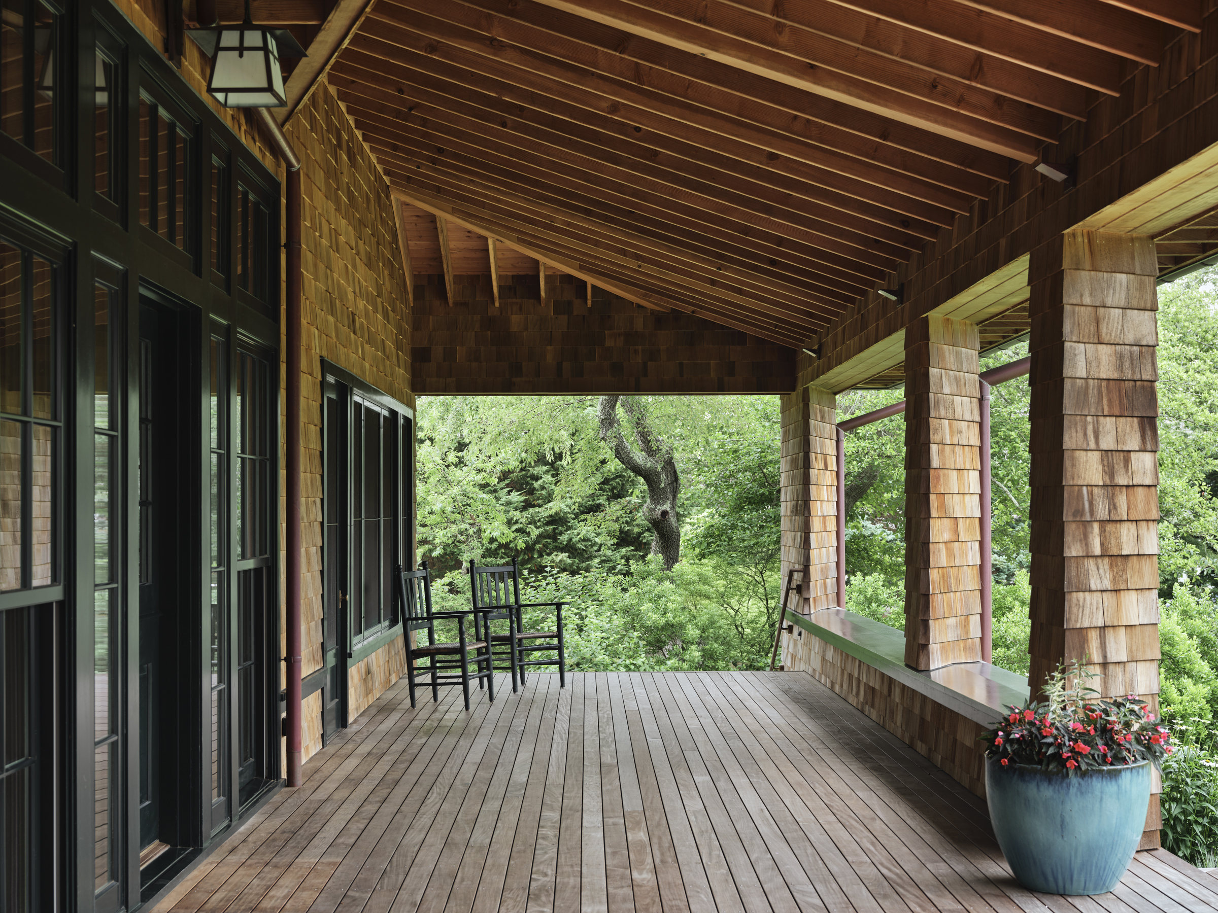 Exposed rafters and shingle-clad columns frame a deep porch