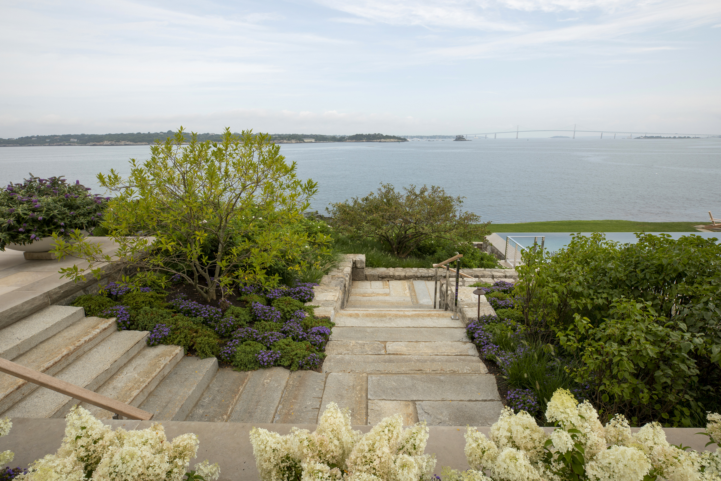 A Newport landscape by Hoerr Schaudt descends through coastal planting toward Narragansett Bay