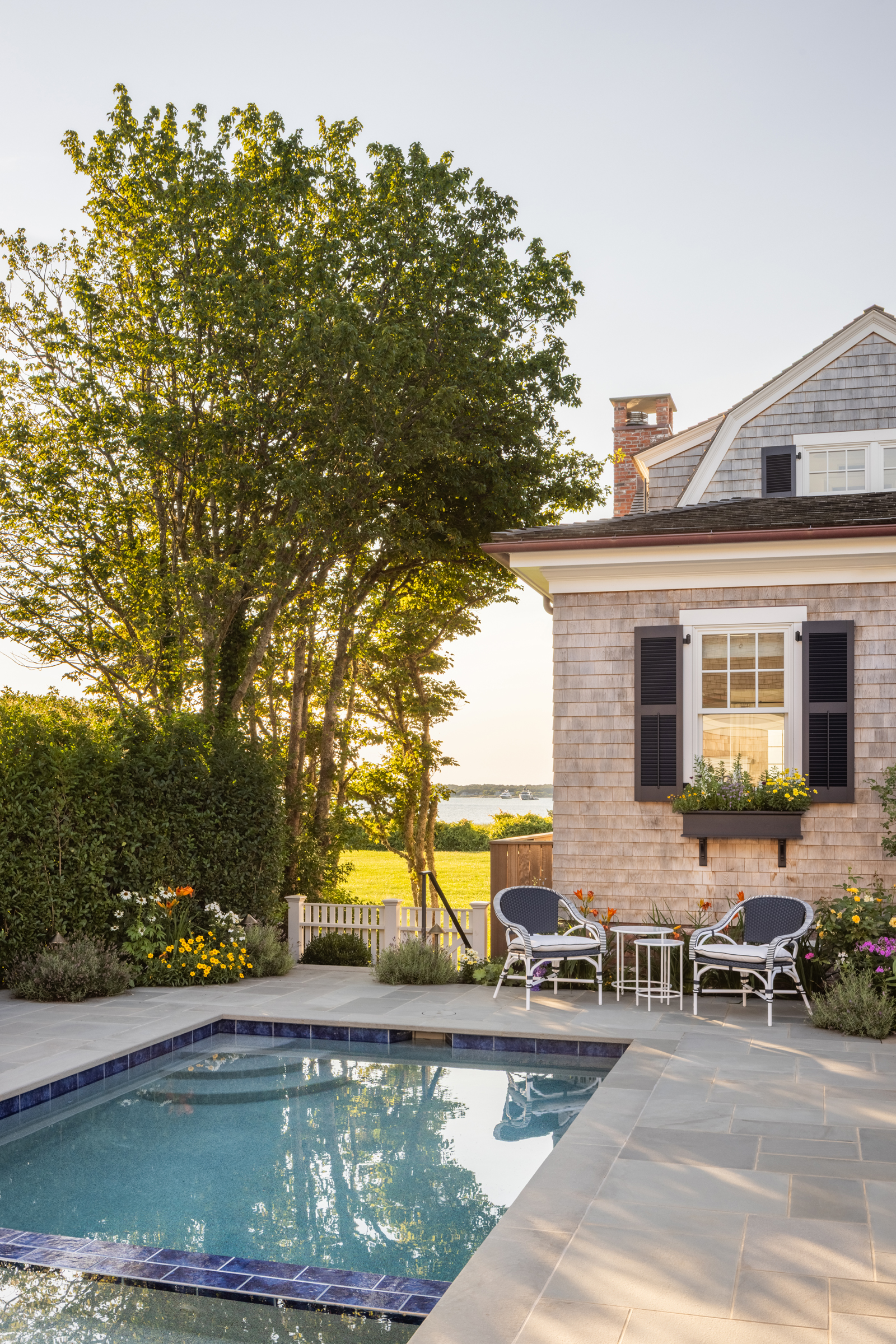 The side-yard swimming pool preserves the lawn and water views along the common green