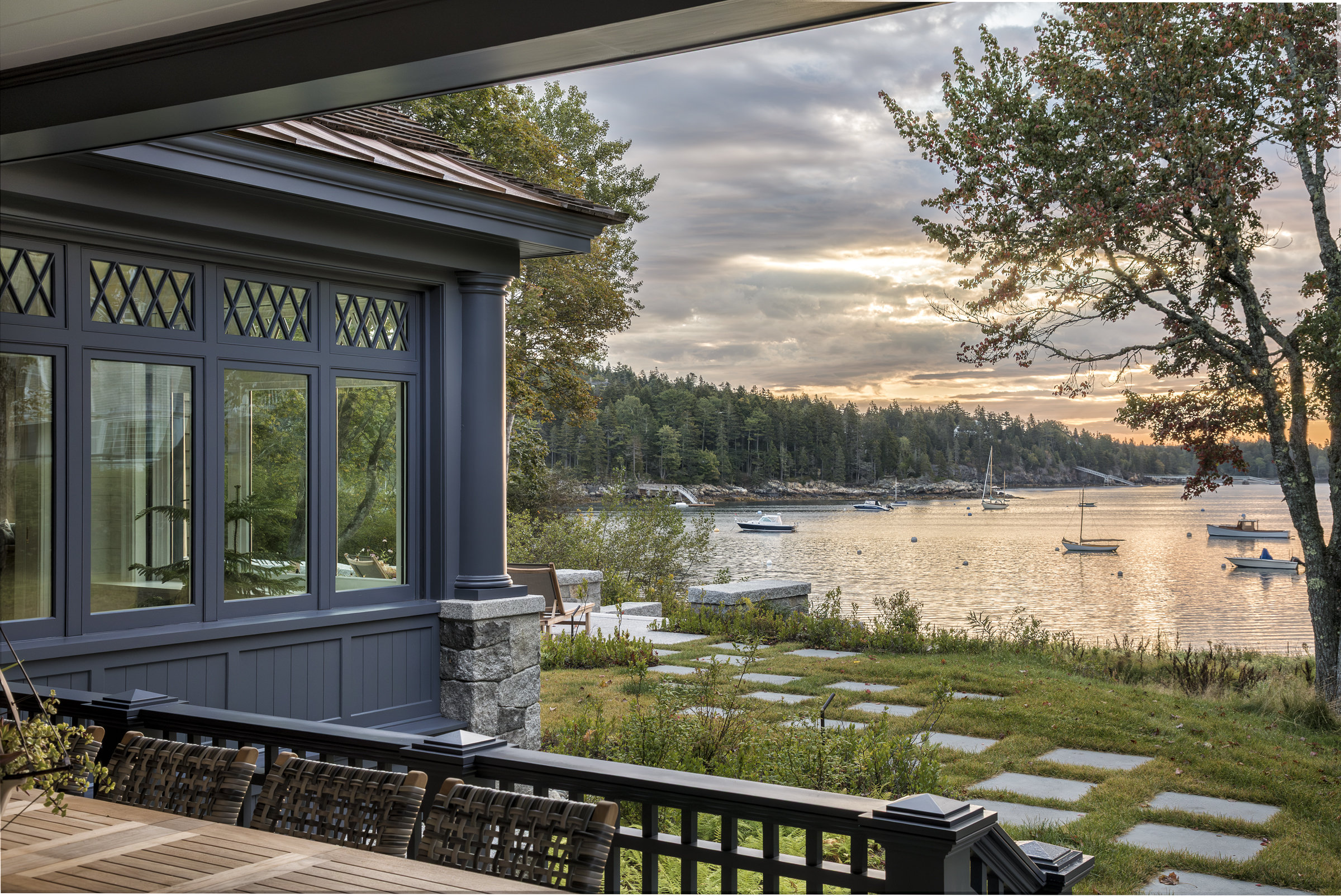A glazed porch with concealed sash windows overlooks the Maine harbor