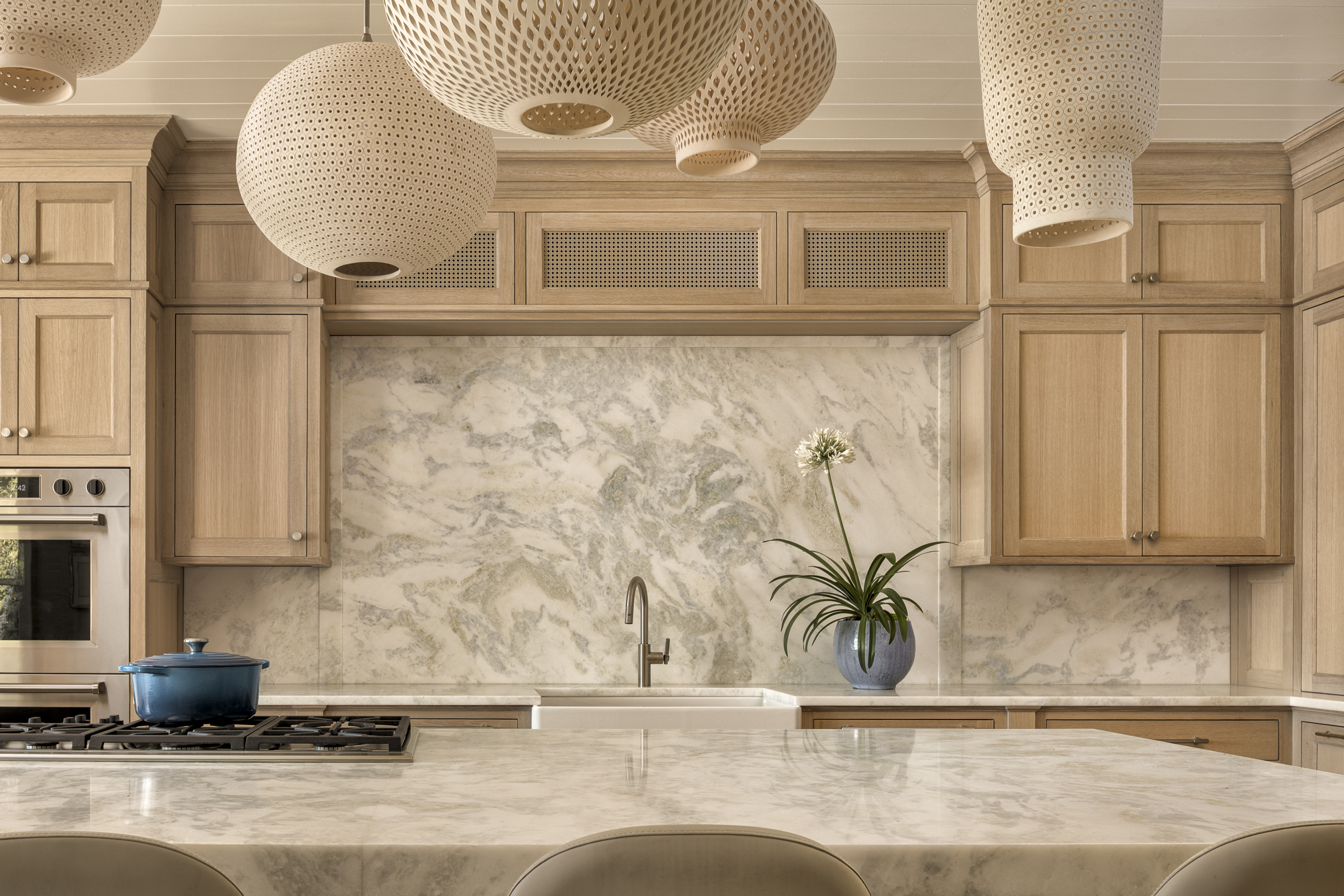 Water-glazed white oak cabinetry and pale stone define the coastal Maine kitchen