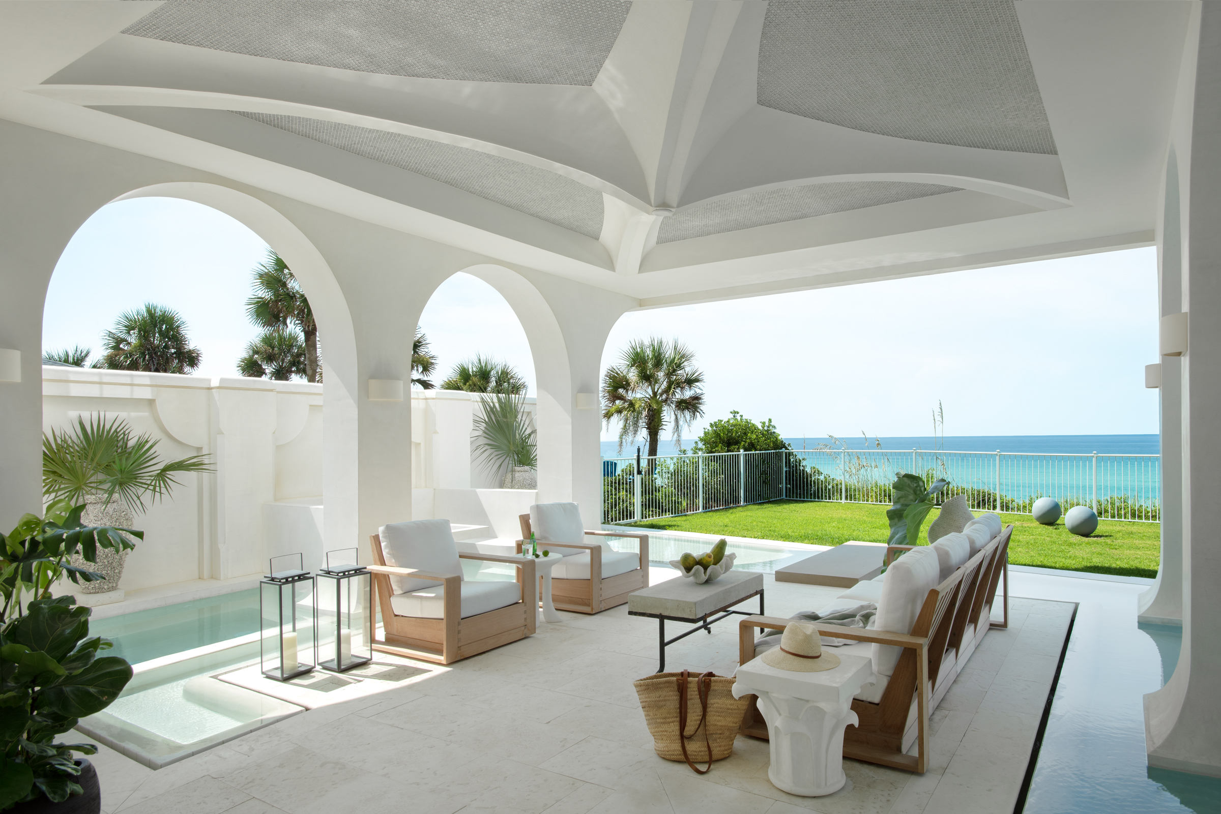 A vaulted white seating pavilion appears to float within a shallow pool
