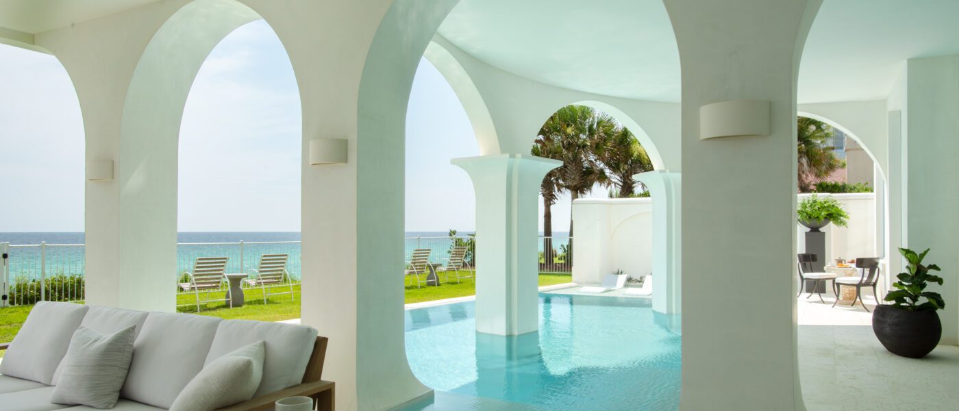 Aegean blue pool water flows around arched white columns overlooking the Gulf