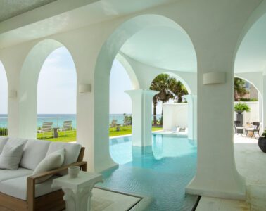 Aegean blue pool water flows around arched white columns overlooking the Gulf