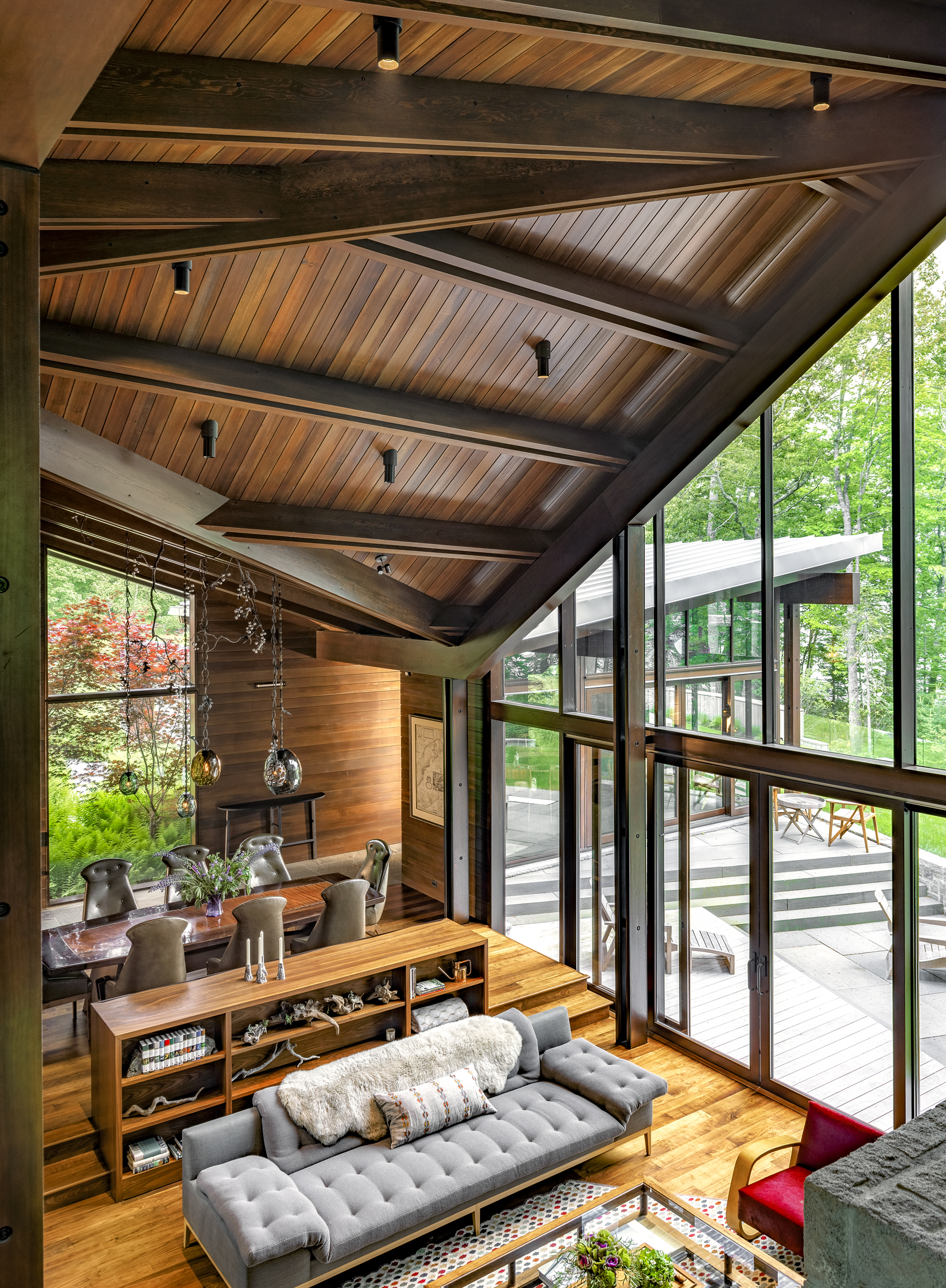 Exposed cedar roof beams extend toward a wall of glass