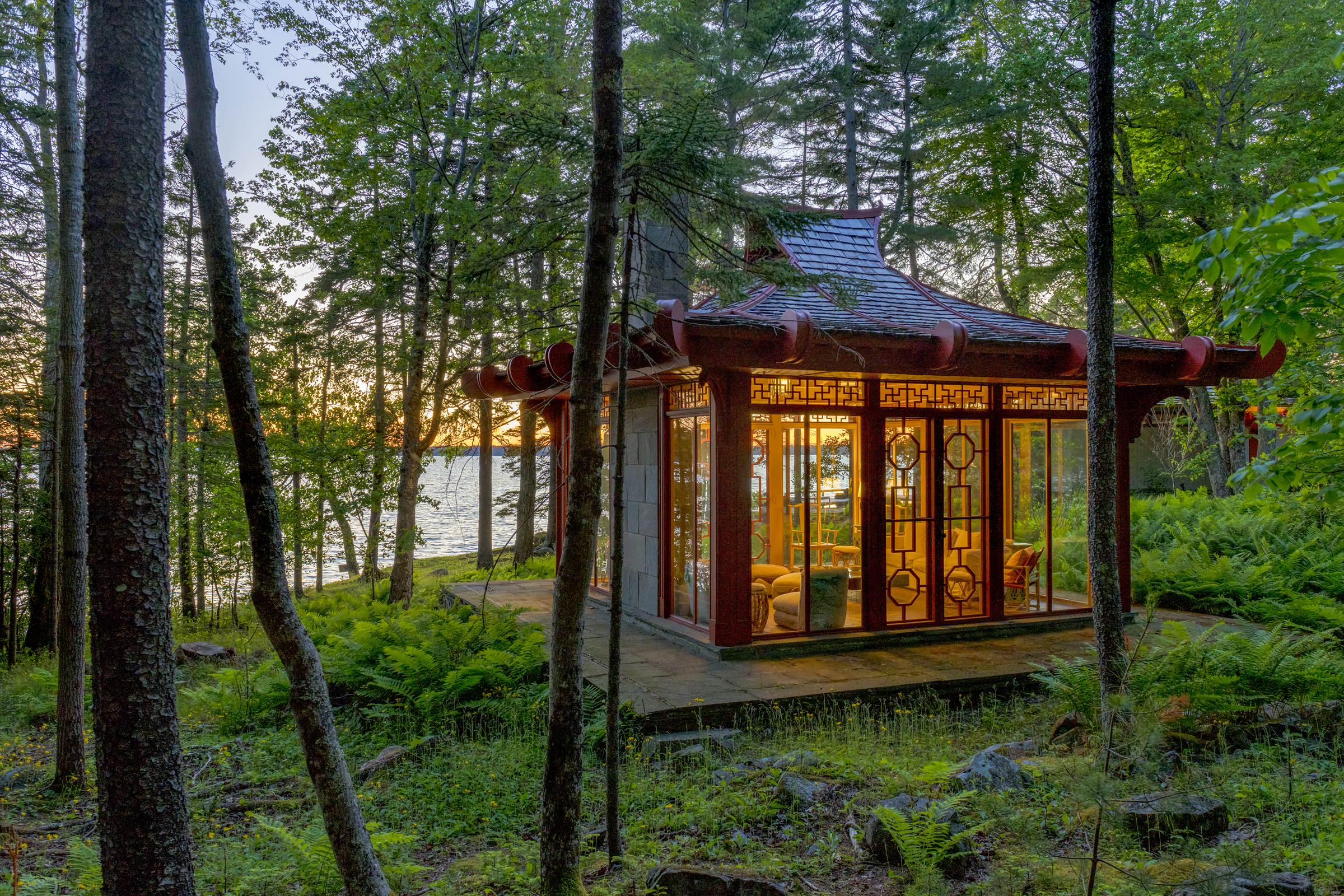 Robert Patterson’s restored 1964 Glass Teahouse glows among trees by the water