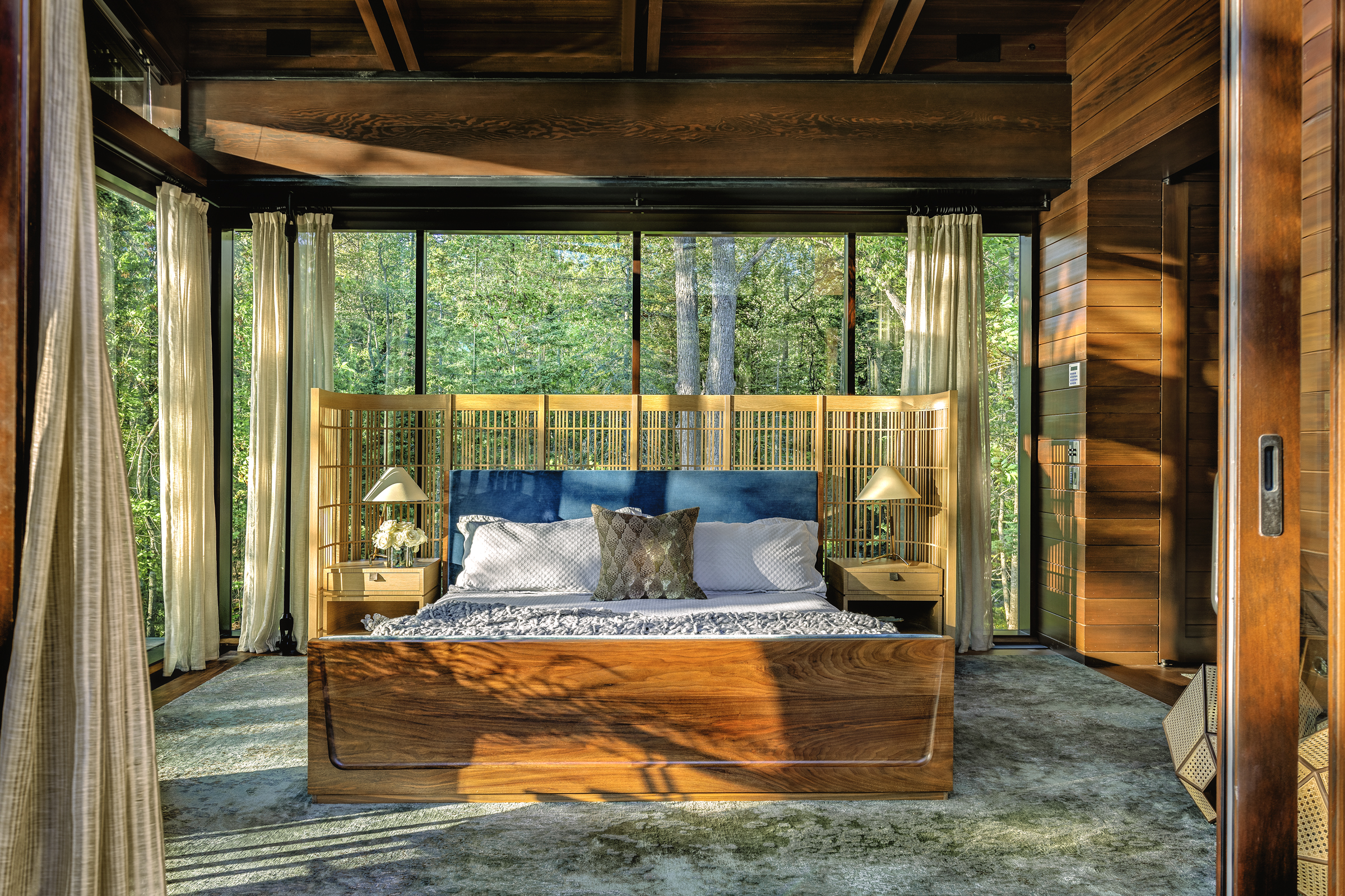 The primary bedroom looks directly into the Maine forest