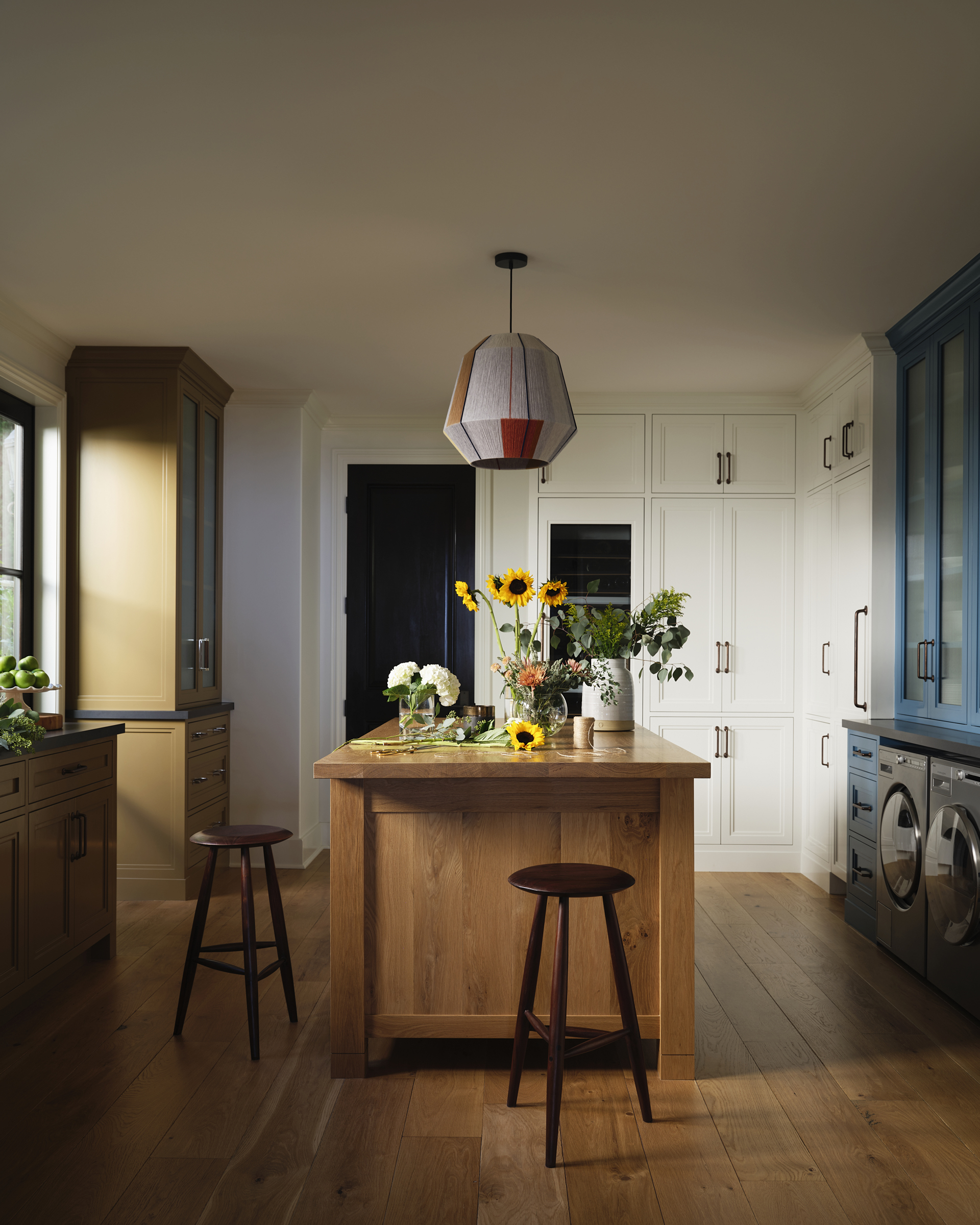 A wood-topped island and blue cabinetry in the adjacent butler’s pantry