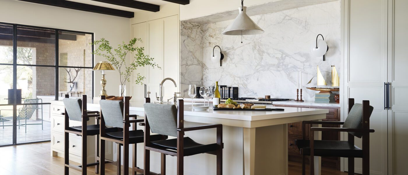 A serene Newport Beach kitchen with concealed cabinetry and a marble niche