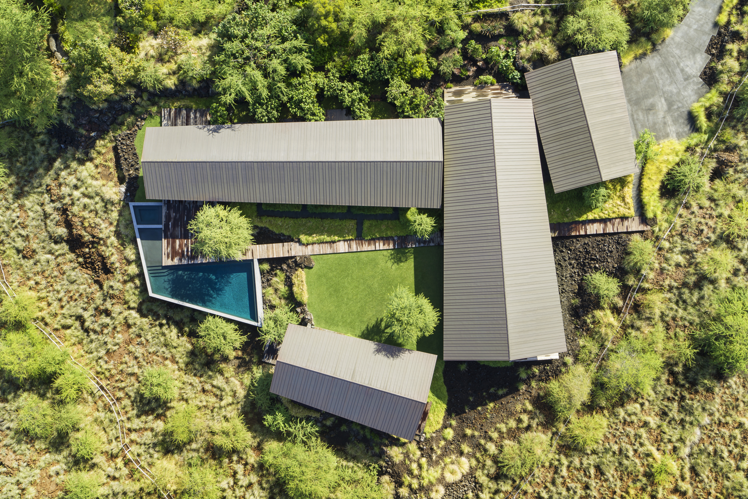 An aerial view reveals separate pavilions organized around a central lawn and pool