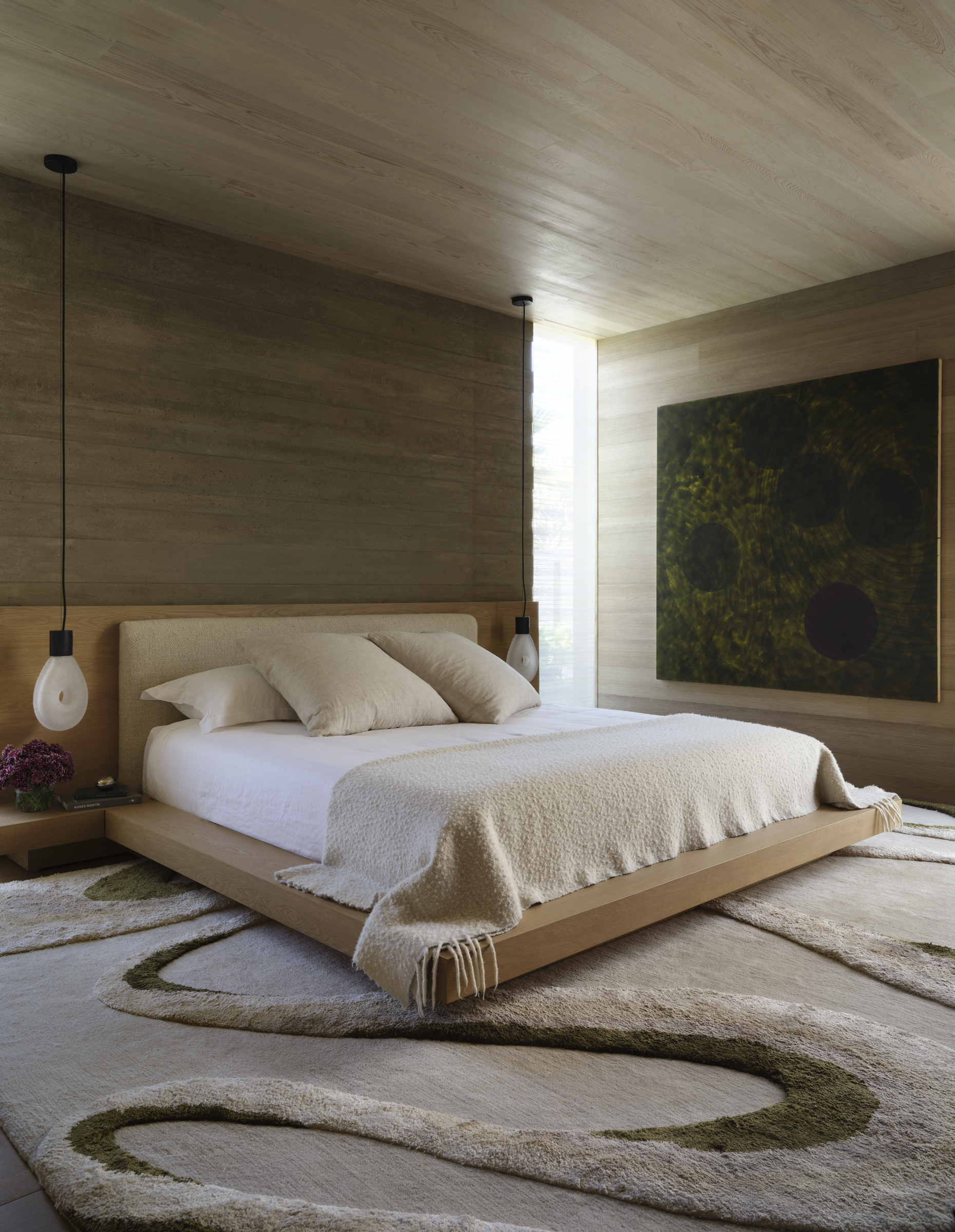 A low platform bed sits between bald cypress and board-formed concrete walls