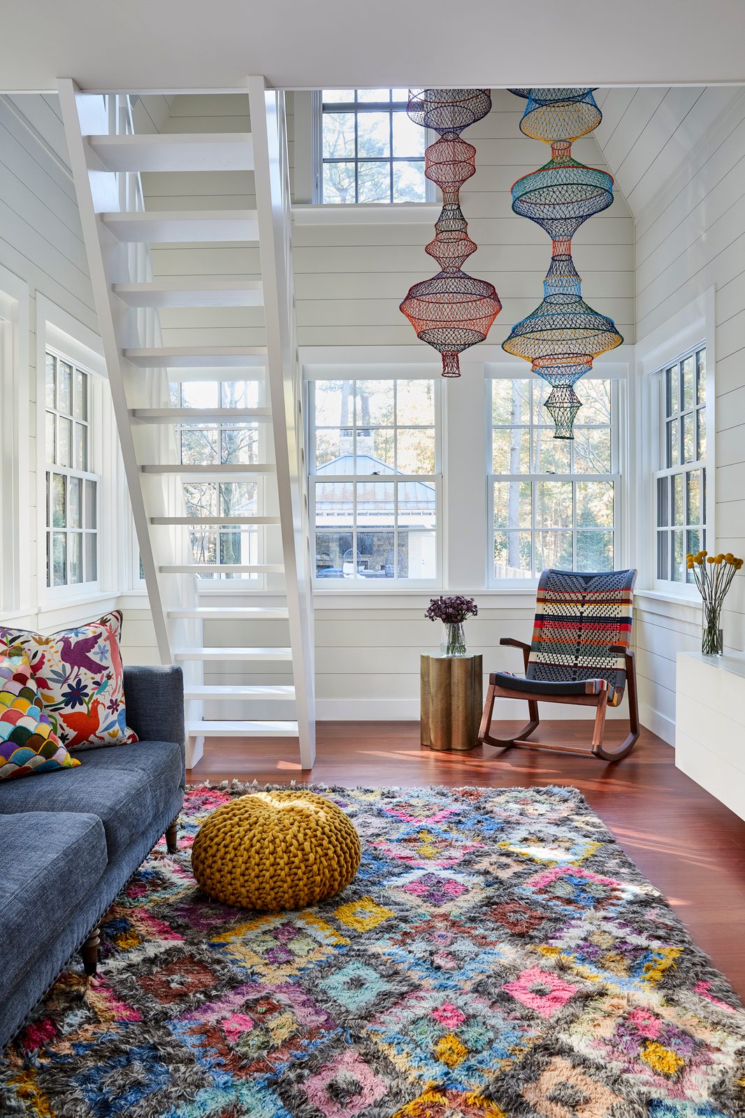 Colorful King’s Way playroom with pendant lights, a patterned rug, and tall windows