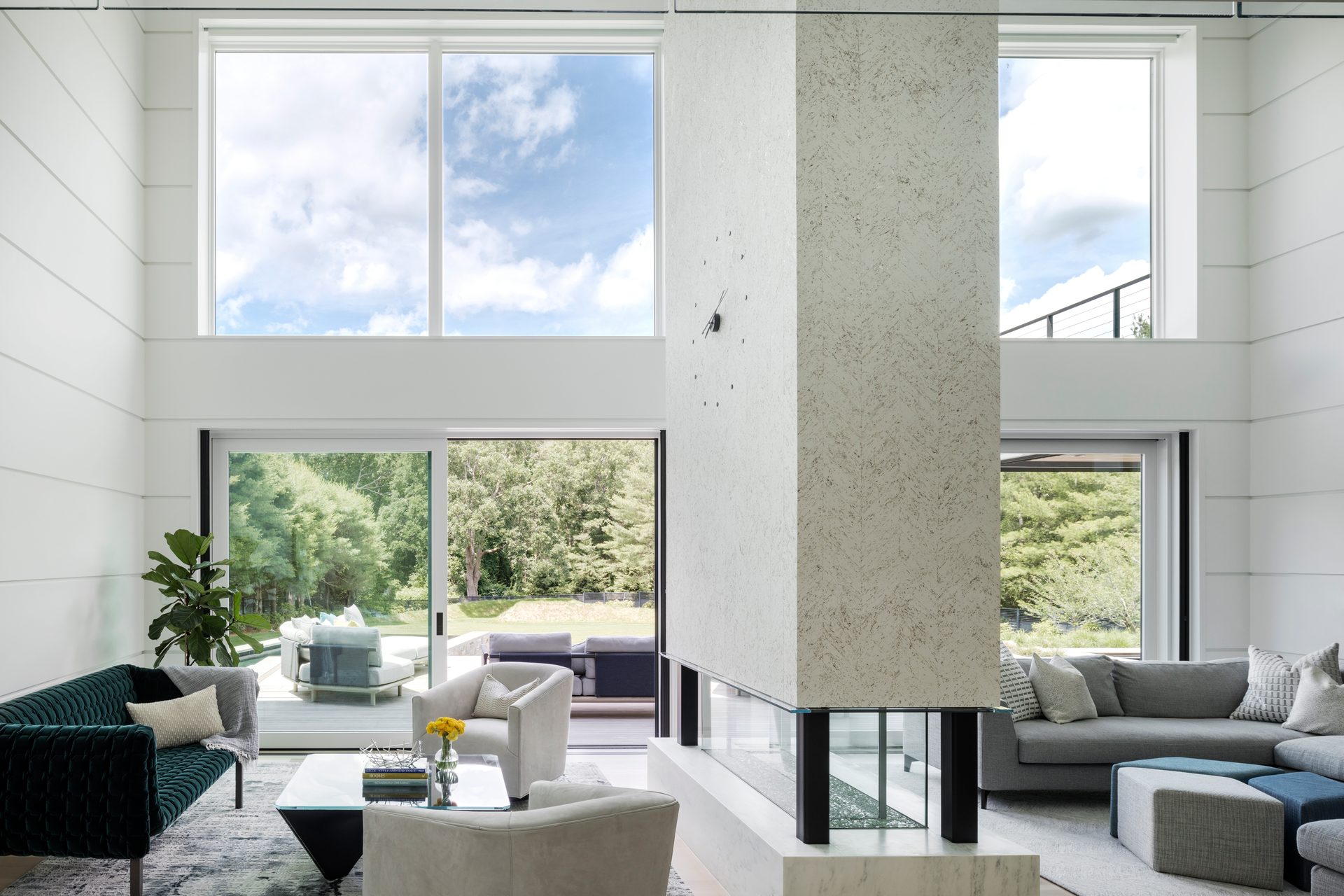 Double-height living space at Terrace Edge arranged around a central four-sided fireplace